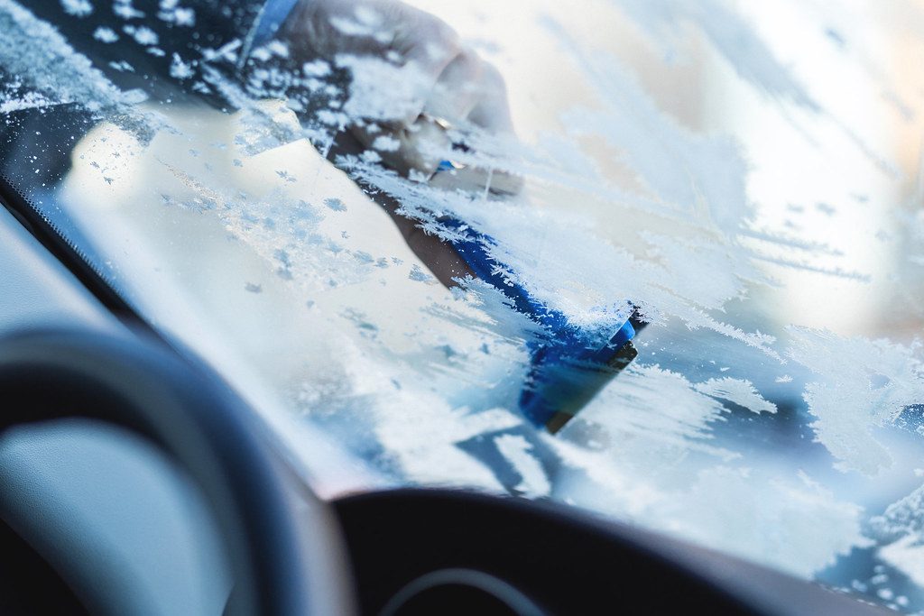 Scraping frost from the inside of a windshield